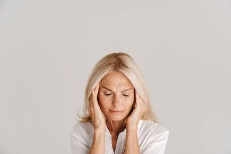 woman holding her head in pain