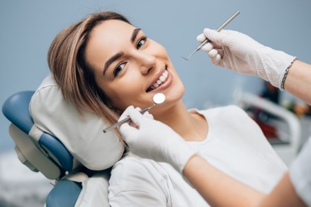 smiling woman next to orthodontic tools
