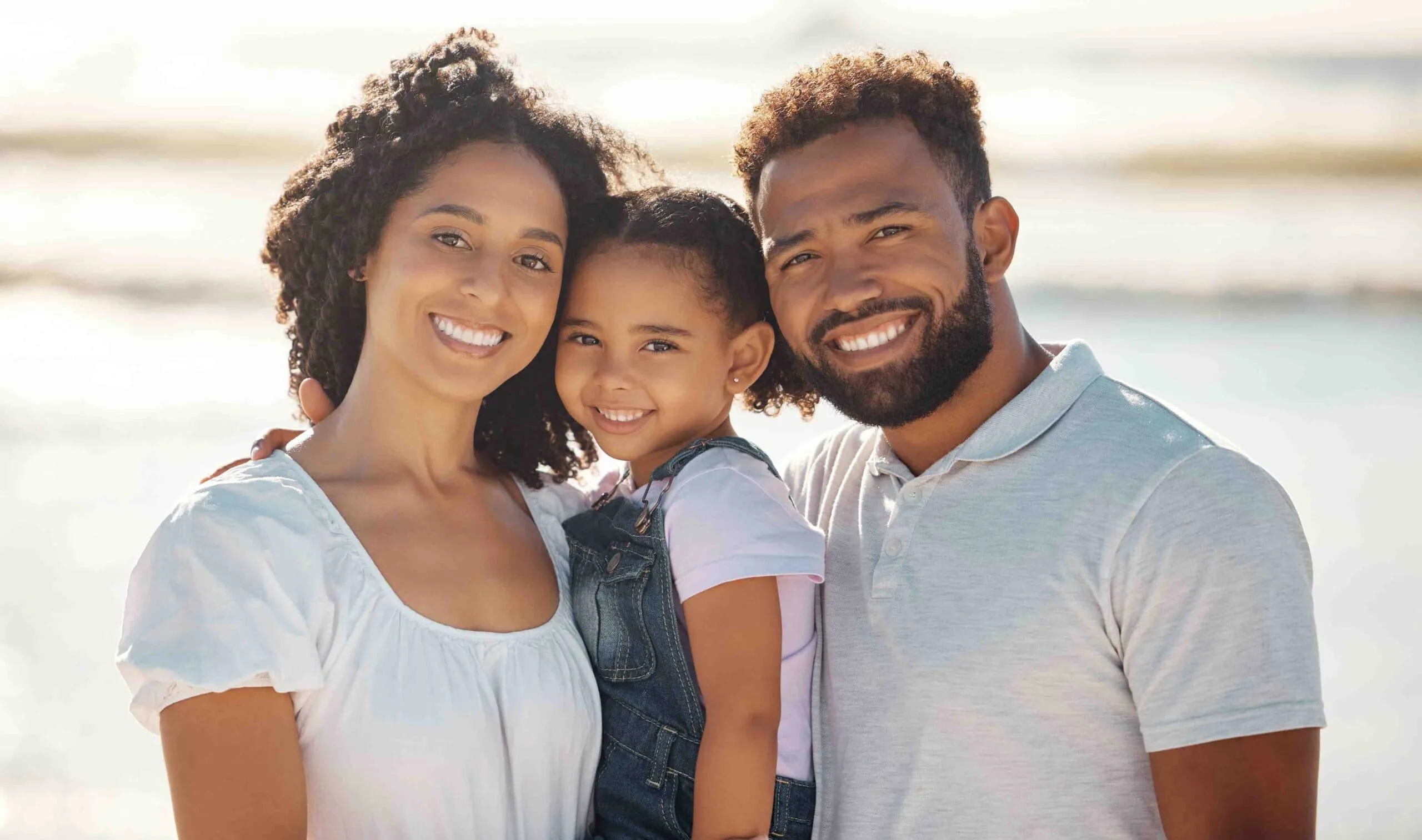 Family smiling on the beach after going to Bartley Orthodontics